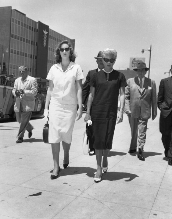 (Original Caption) 6/23/1958-Hollywood, CA: Cheryl Crane (Left) talks with her mother, Lana Turner,in the office of attorney William Pollack where depositions are being taken by Pollack in the $705,000 damage suit being brought in behalf of John Stompanato III. The suit is the result of the stabbing of Johnny Stompanato in April. Defendants are Miss Turner, her daughter, and stephen Crane, Cheryl's father. In background is attorney Jerry Giesler, who is acting for Miss Turner.