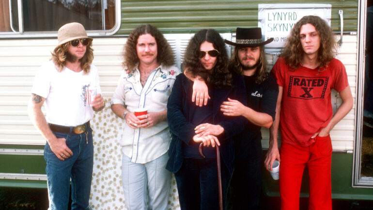 CALIFORNIA - OCTOBER 1976: Members of Southern Rock band Lynyrd Skynyrd (L-R Leon Wilkeson, Billy Powell, Gary Rossington, Ronnie Van Zant and Allen Collins) pose by their trailer backstage at an outdoor concert in October, 1976 in California.