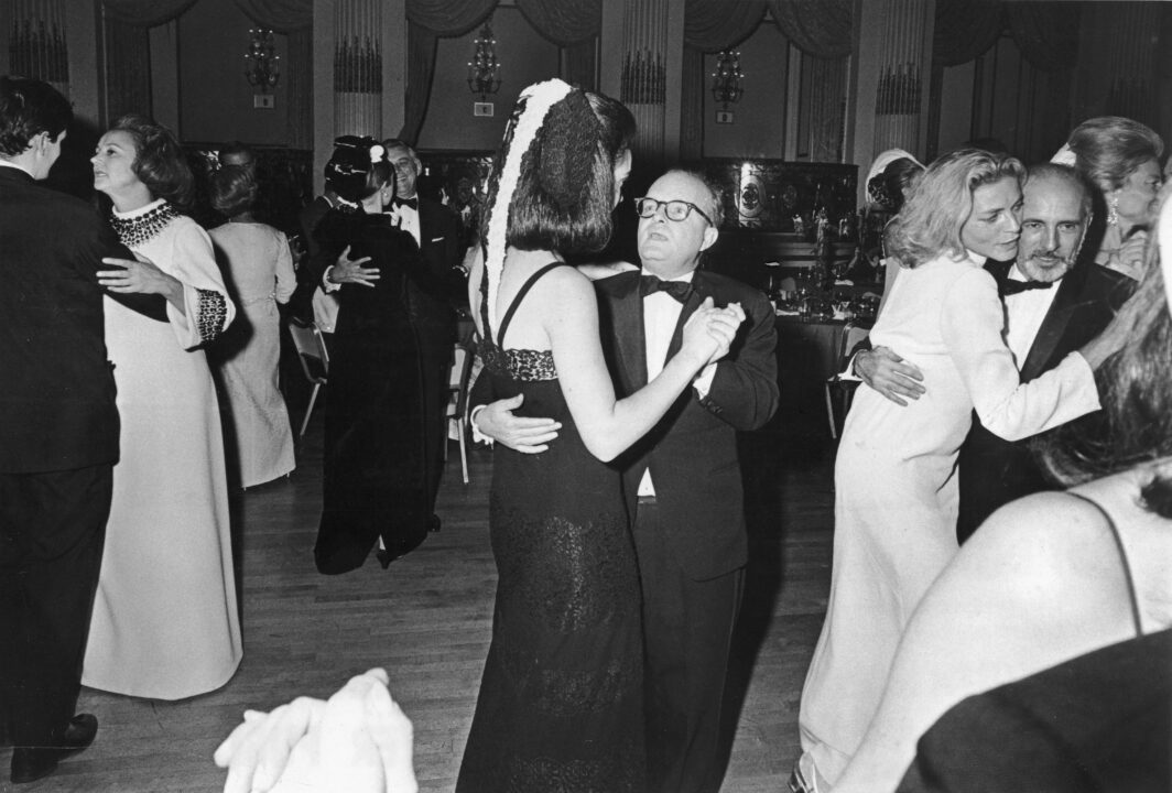 American novelist, short story writer, and playwright Truman Capote (1924 - 1984) (center) dances with Wendy Vanderbilt (later Lehman) at his Black-and-White Ball held in the Grand Ballroom of the Plaza Hotel, New York, New York, November 28, 1966. To the left, American publisher Katherine Graham (1917 - 2001), publisher of the Washington Post and Capote's guest of honor dances with an unidentified man. To the right, American actress Lauren Bacall dances with American dancer and choreographer Jerome Robbins (1918 - 1988). 