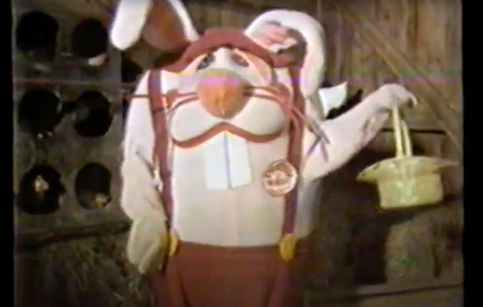 image from a 1981 commercial for the Shake-an-Egg Easter egg coloring kit. The product's mascot, Dudley Rabbit, is holding an Easter basket in his left hand as he faces the viewer. 