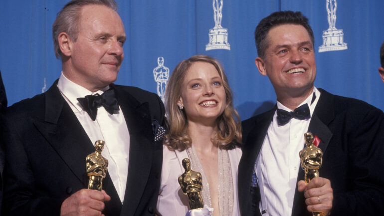 image from the 1992 Oscar ceremony picturing, from left to right, Anthony Hopkins, Jodie Foster and Jonathan Demme, each holding the Oscar award they won for 