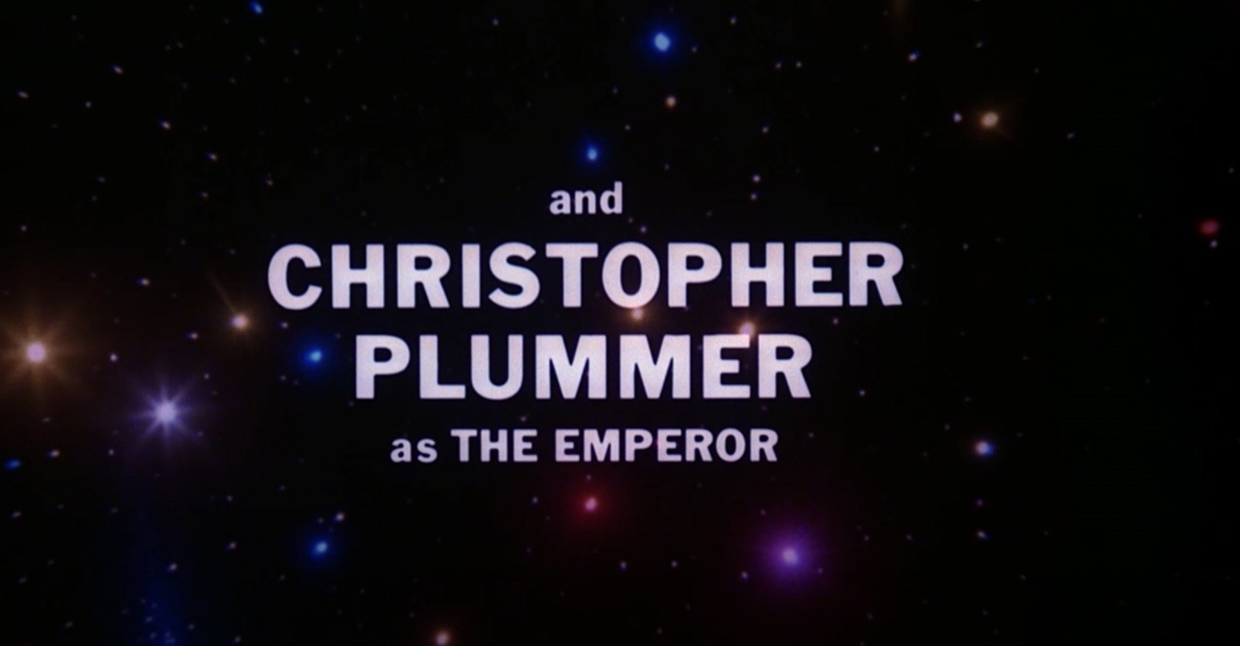 image from the opening credits of the 1979 space opera movie "Starcrash." In white lettering, against a dark and starry space background, reads: "and CHRISTOPHER PLUMMER as THE EMPEROR 