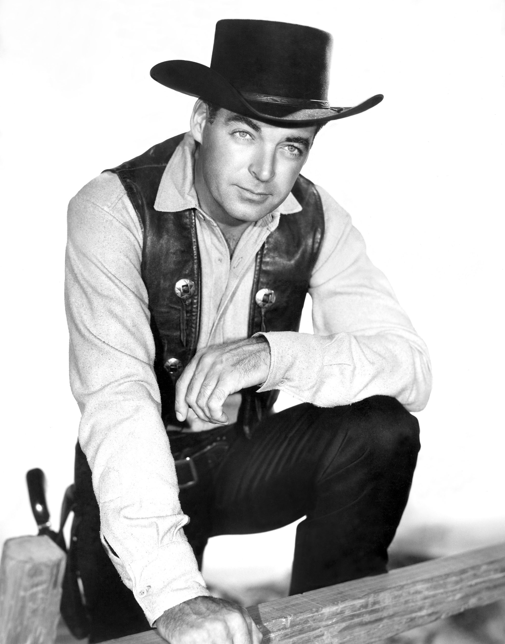 black and white image from the 1958-60 Western TV series "The Texan." It shows star Rory Calhoun dressed as an old west lawman, with hat, leather vest, holster with gun. 