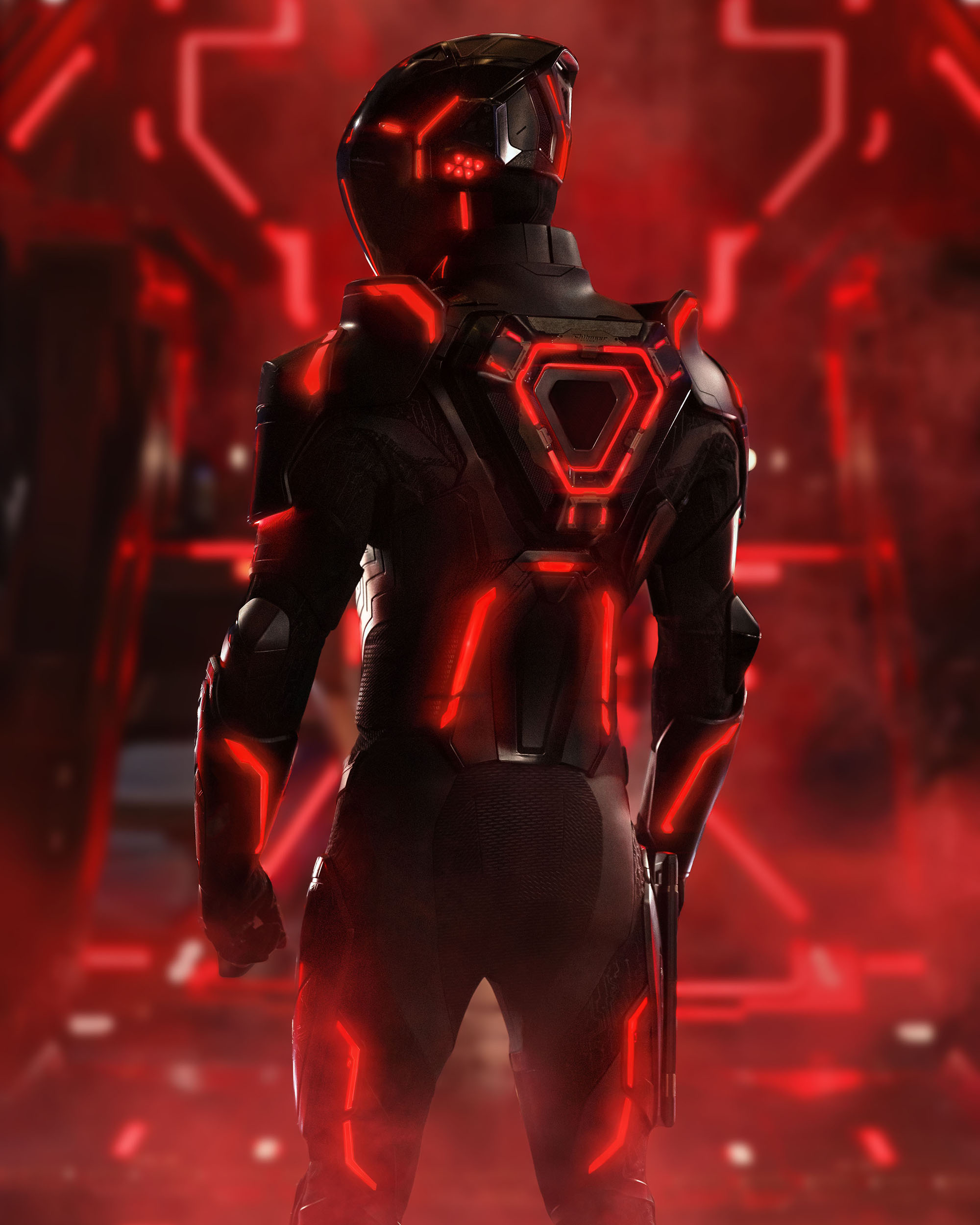 first look from Disney's 2025 live-action movie "Tron-Ares." We see a figure in black, Ares, dressed in a black suit and helmet. He is inside a computer world that is illuminated by a red light that contrasts in the background against his black suit.