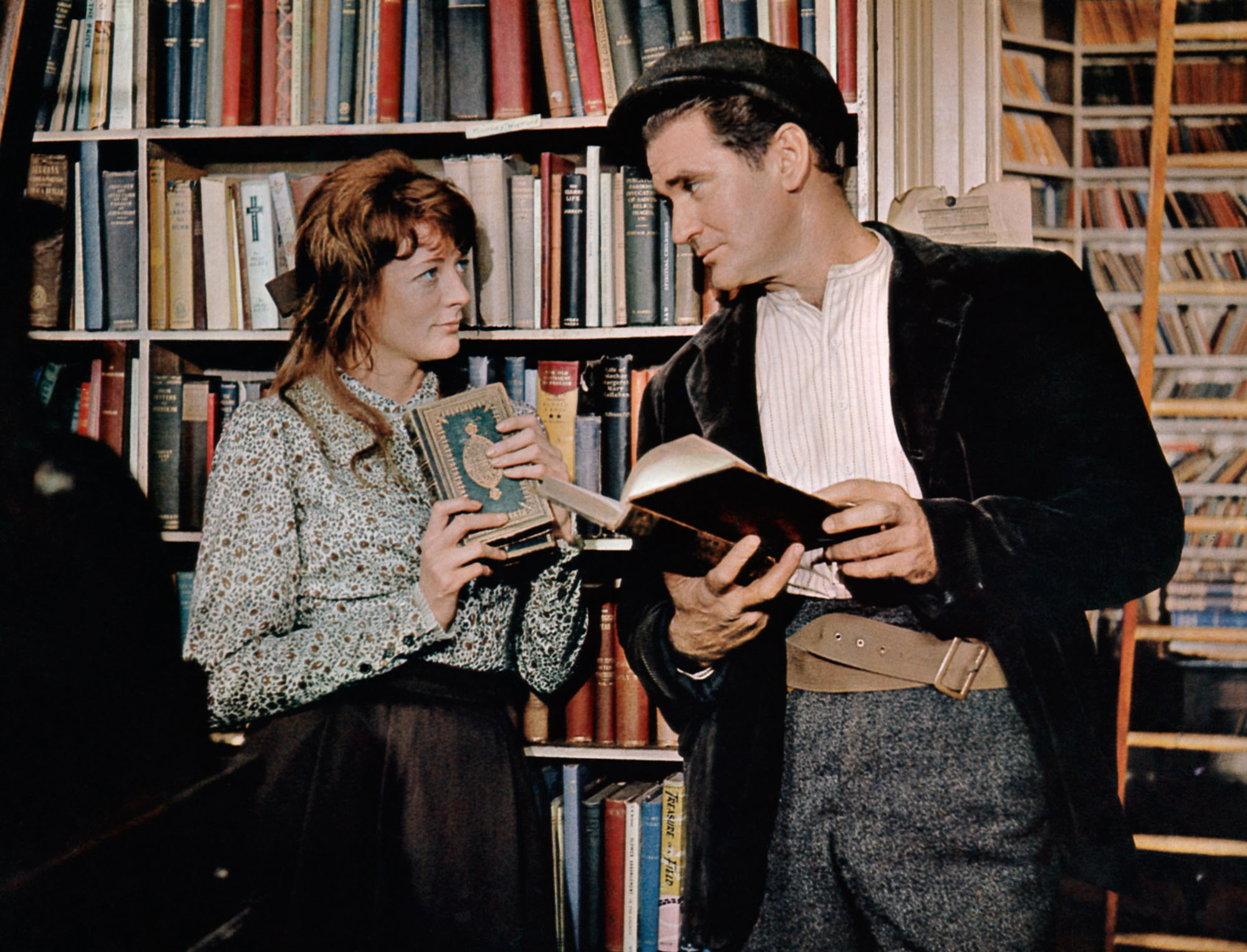 image from the 1965 movie "Young Cassidy." Maggie Smith as Nora on the left, and Rod Taylor as John Cassidy, on the right, are standing in an early 20th century bookshop in Ireland, looking fondly upon one another.