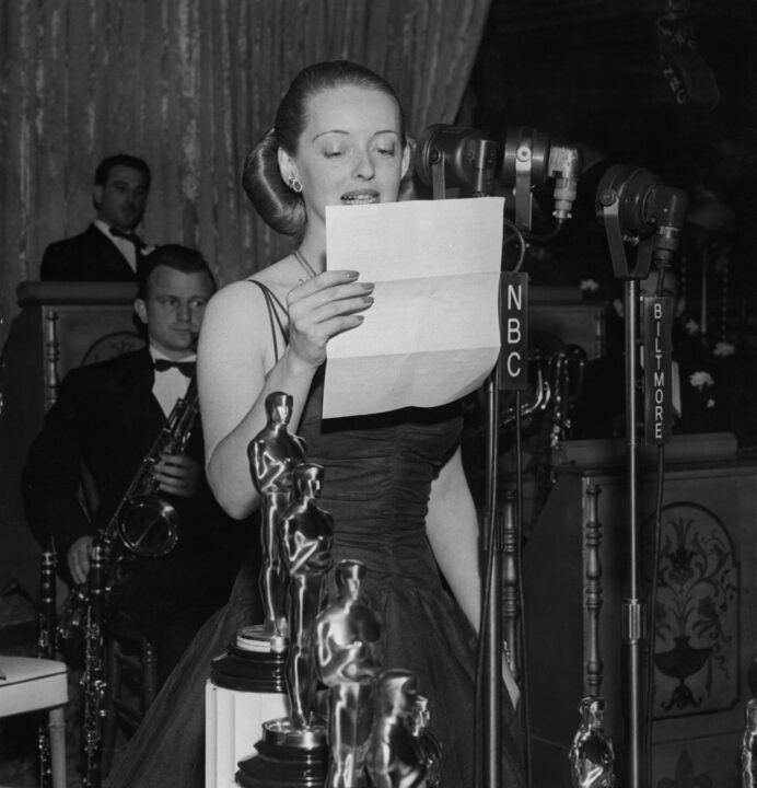 THE 13TH ANNUAL ACADEMY AWARDS -- Pictured: Bette Davis thanks President Roosevelt for his talk at the Motion Picture Academy banquet during the 13th Annual Academy Awards held at the Biltmore Bowl in the Biltmore Hotel in Los Angeles, California on February 27, 1941-- 