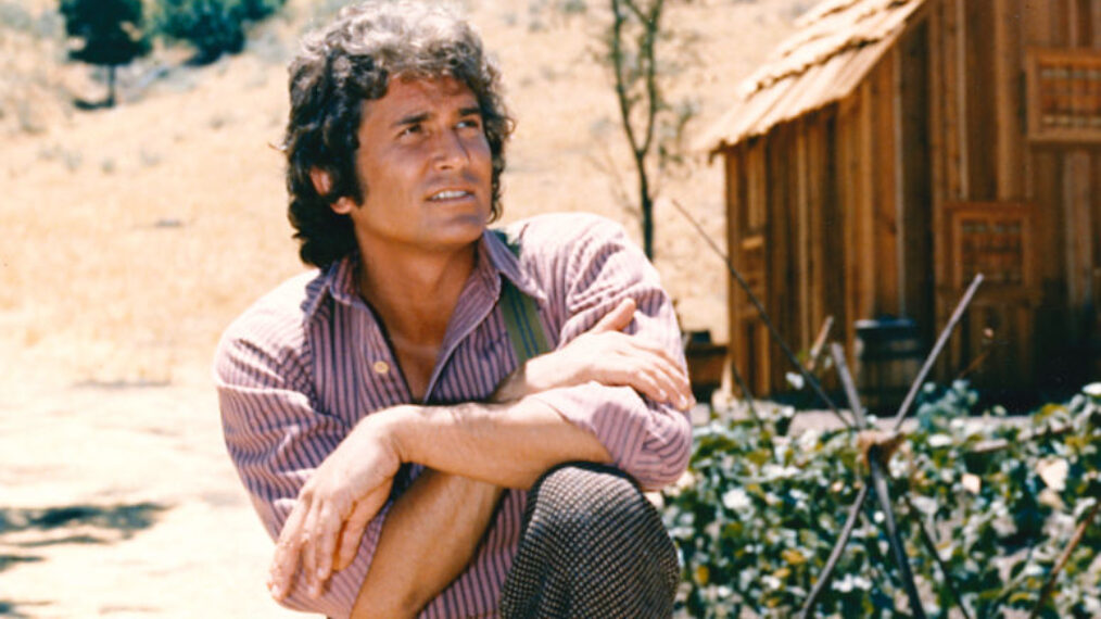 Michael Landon (1936-1991), US actor, poses with his arms crossed and resting on his knee with a log cabin the background in a portrait issued as publicity for the US television series, 'Little House on the Prairie', circa 1974. The drama, adapted from the novels by Laura Ingalls Wilder (1867-1957), starred Landon as 'Charles Ingalls'