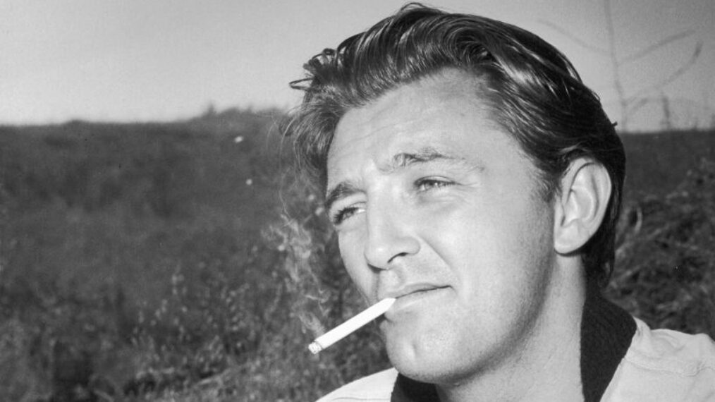 circa 1948: American actor Robert Mitchum (1917-1997) holds a book of matches while smoking a cigarette outdoors