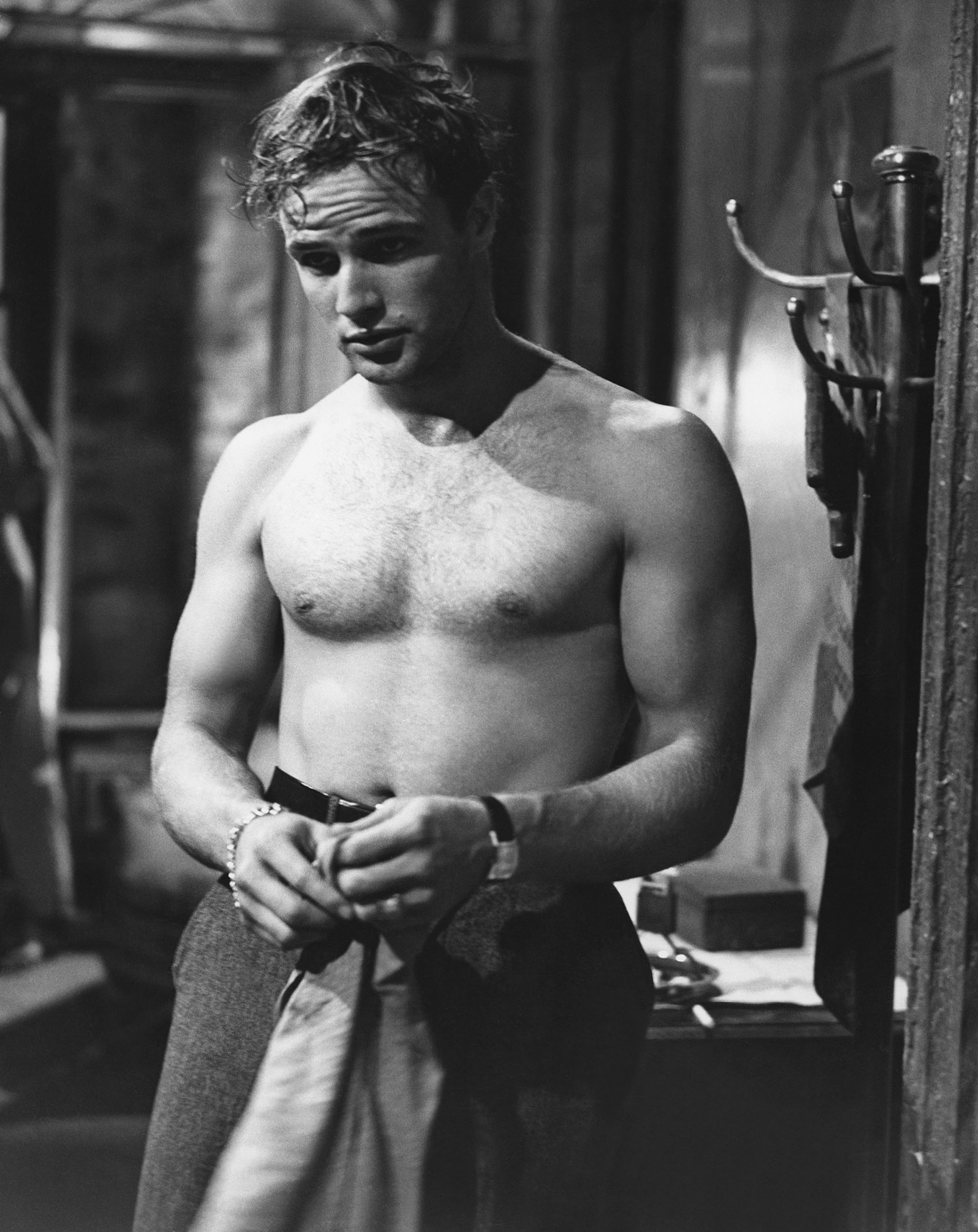 black and white image from the 1951 movie "A Streetcar Named Desire." Shown is Marlon Brando as Stanley Kowalski, standing and shirtless, in the vertical photo.