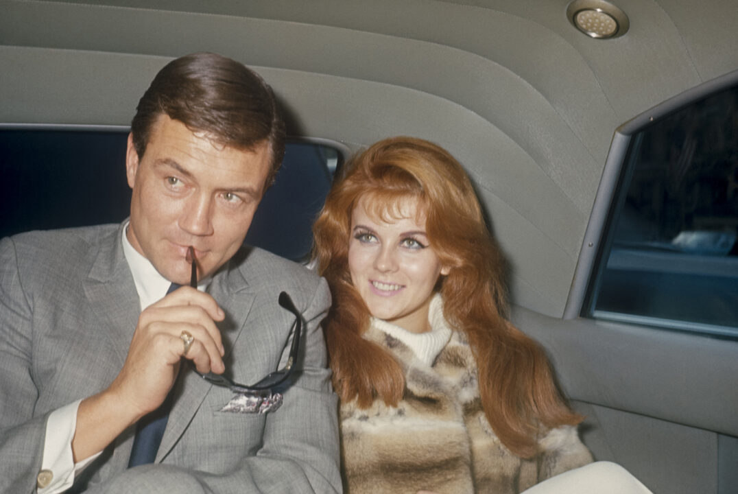 Roger Smith with sun glasses and Ann-Margret in the back of a limo; circa 1970; New York.