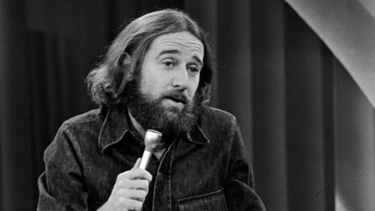 American comedian George Carlin performs his stand-up comedy act on stage, 1981
