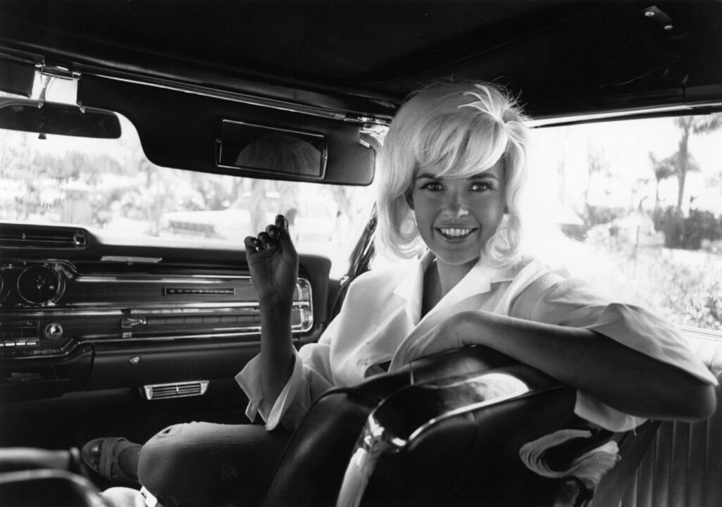 Vera Jane Palmer (1933 - 1967) better known as Jayne Mansfield, an American actress in the passenger seat of a limousine.
