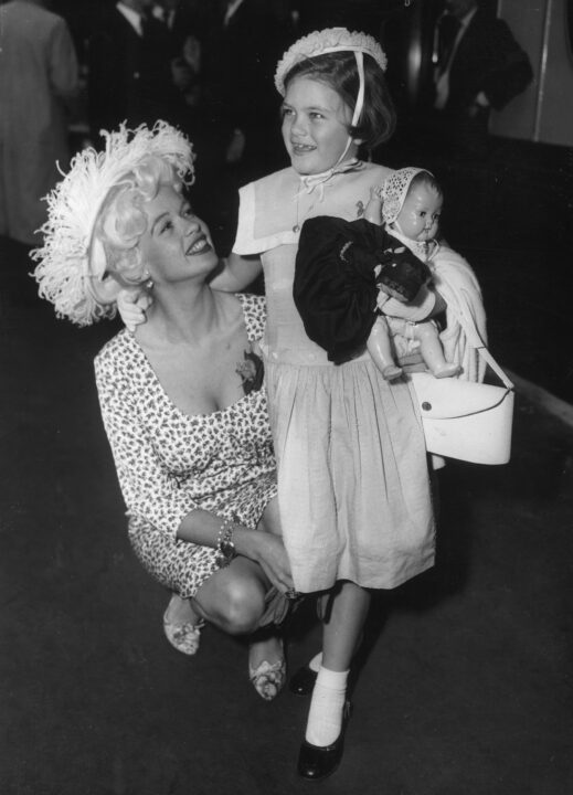 23rd July 1958: Hollywood sex symbol Jayne Mansfield (1933 - 1967) leaves London's Waterloo Station with her daughter Jayne Marie. She is catching the SS Queen Elizabeth boat train to New York, having finished work on the comedy western 'The Sheriff of Fractured Jaw' in Britain. 
