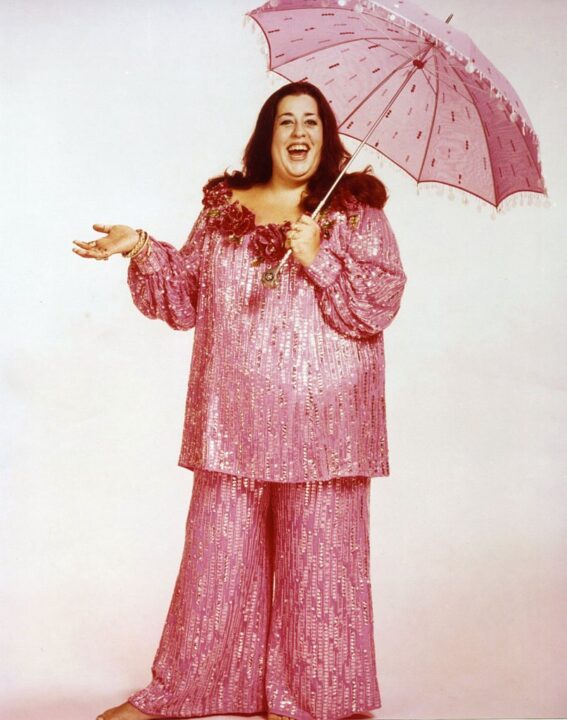 CIRCA 1970: Singer Cass Elliot poses for a portrait with an umbrella and matching pink suit circa 1970