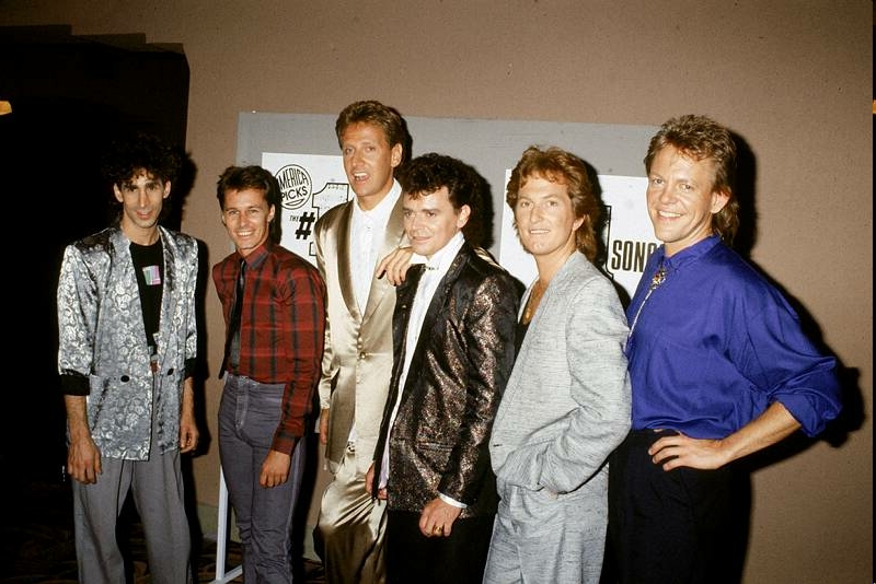 Australian soft rock group Air Supply, led by Russell Hitchcock (4th from left) and English-born Graham Russell (5th from left), pose for a photograph backstage at the 'America Picks #1 Songs' at the Wiltern Theater in Los Angeles, May 21, 1986. The other members of the band are David Moyse, David Green, Ralph Cooper, and Frank Esler-Smith.