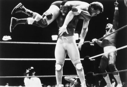 (Original Caption) New York: Wrestling champion Hulk Hogan (Right) shows enthusiasm as television's Mr. T, his partner in a tag team wrestling match, gets Rowdy Roddy Piper up on his shoulders for a slam to the mat 3/31. Hogan and Mr. T beat Piper and Paul Orndorff in the main event of a big wrestling program.