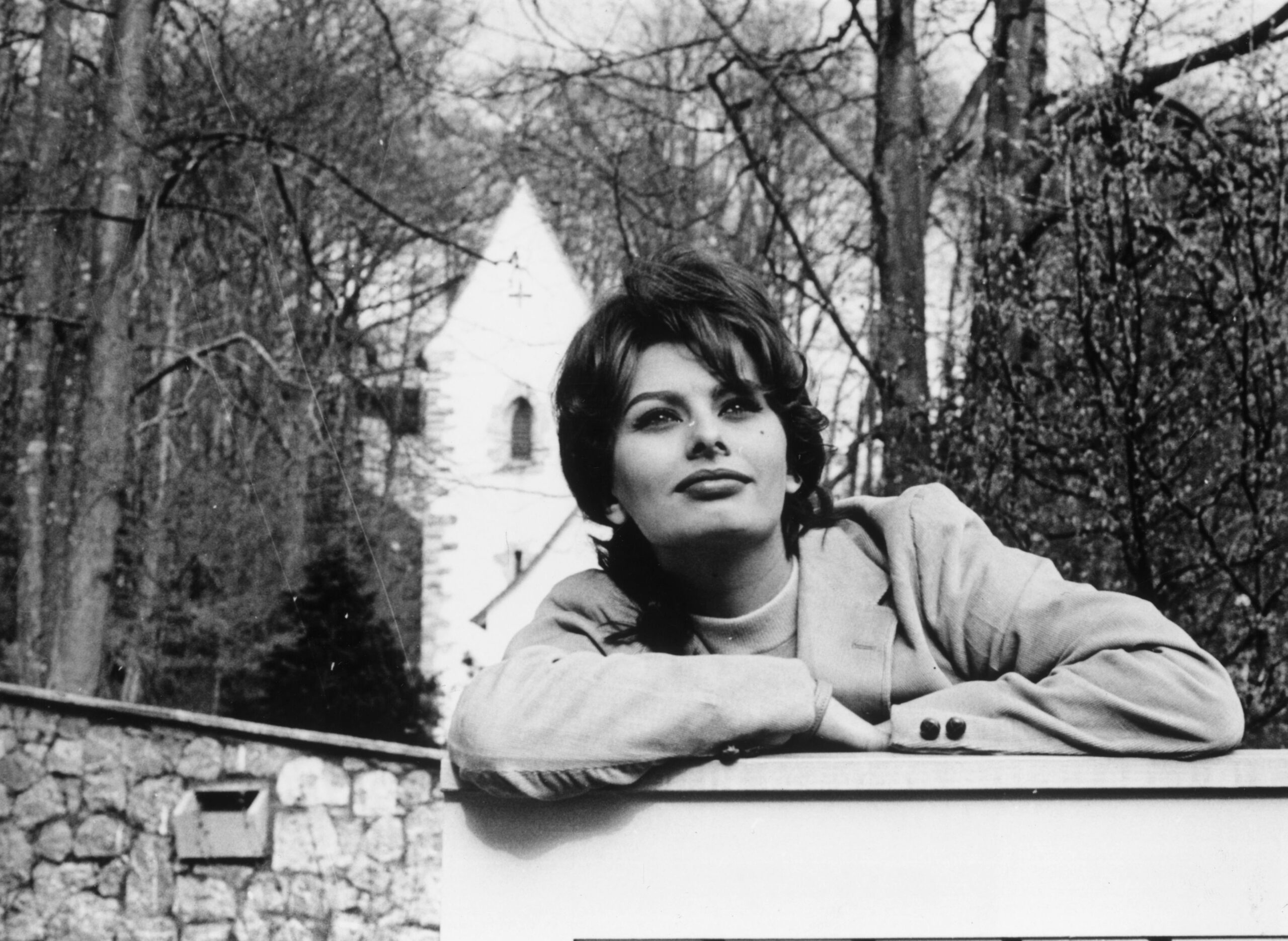 Film star Sophia Loren leans on the gate of her home in Switzerland where she is resting from between films.