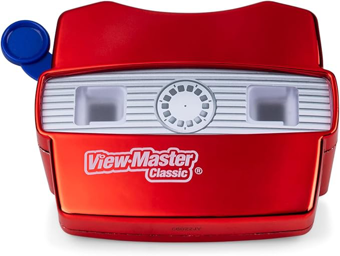 image of a modern "View-Master Classic" handheld camera/projector. The red camera is sitting against a white backdrop, with its back faced outward. Below the eyeholes reads "View Master Classic." On the left is a blue switch for flipping the slides in the reel (this camera does not have a reel inserted into it).