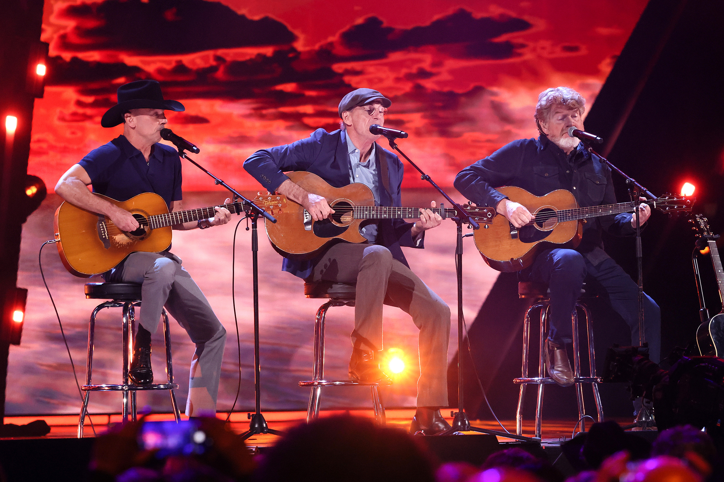 CLEVELAND, OHIO - OCTOBER 19: (L-R) Kenny Chesney, James Taylor, and Mac McAnally perform onstage during the 2024 Rock & Roll Hall of Fame Induction Ceremony streaming on Disney+ at Rocket Mortgage Fieldhouse on October 19, 2024 in Cleveland, Ohio.