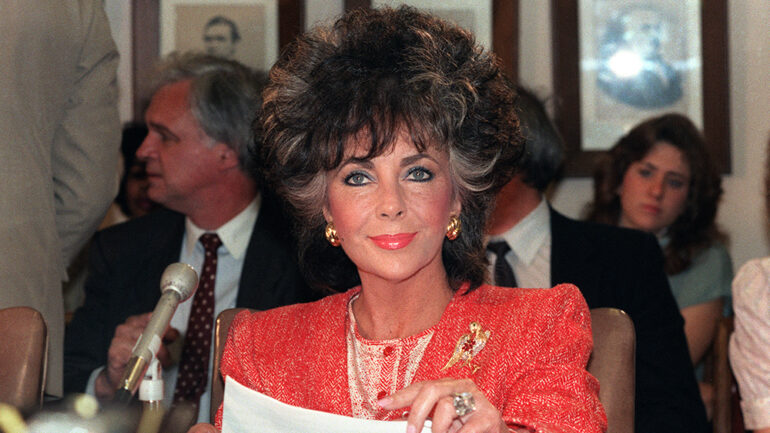 Movie star Elizabeth Taylor smiles as she appears before the Labor, Health and Human services Senate Subcommittee on May 8, 1986 in Washington. Liz Taylor appears as chairman of the American Foundation for Aids Research and appealed for more funds for AIDS research.