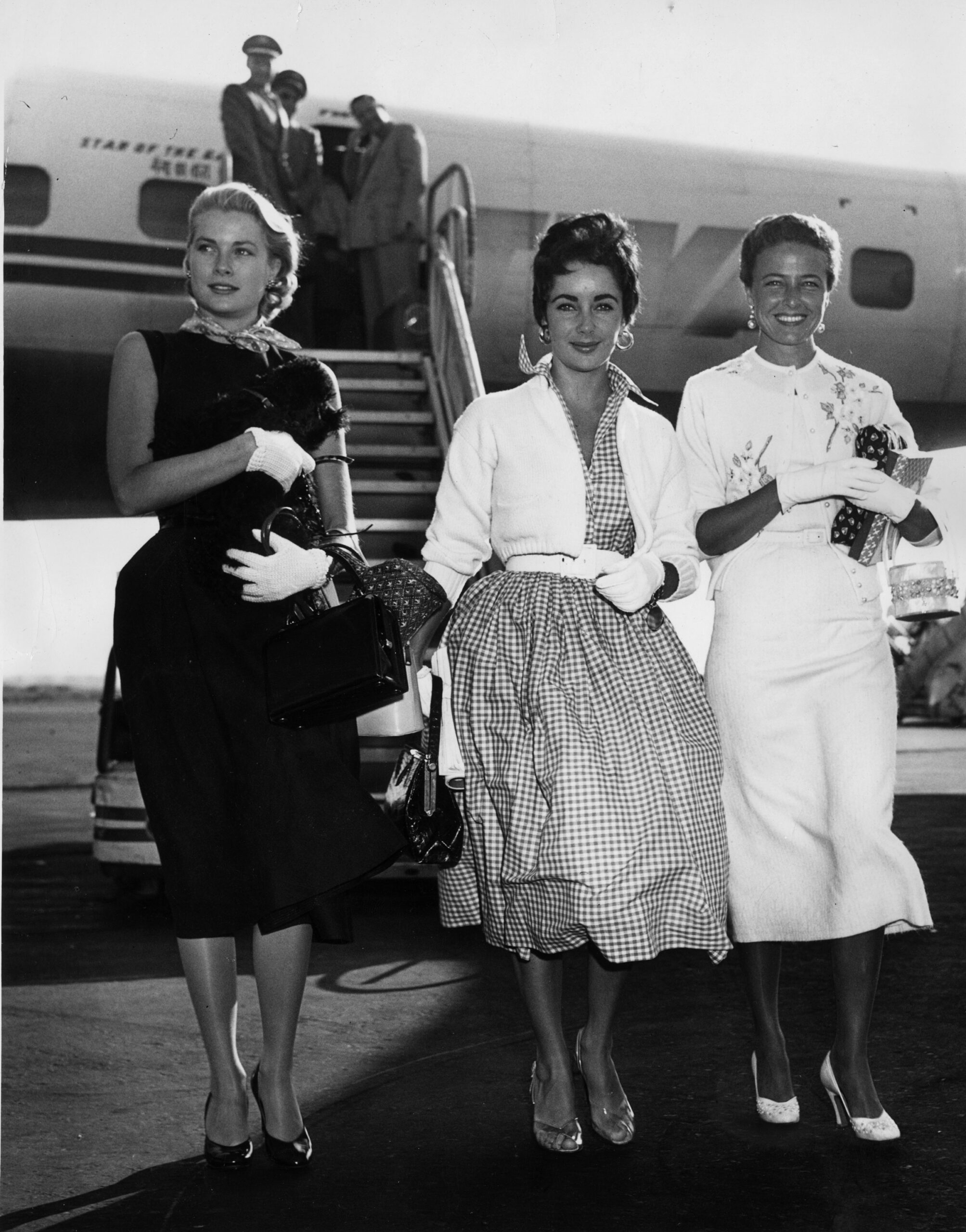 circa 1955: British born American actress Liz Taylor arrives in New York International Airport with fellow actresses Grace Kelly (1929 - 1982) and Lorraine Day. (Photo by Keystone/Getty Images)