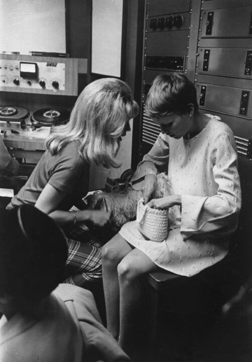 March 1967: Nancy Sinatra shares a moment with her father's third wife actress Mia Farrow during a break at a recording studio.