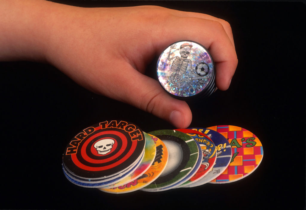 NEW YORK, NY - JUNE 1: Product shot of "pogs "photographed June 1, 1995 in New York City. During pogs gameplay, each player has his or her own collection of pogs and one or more slammers. The players each contribute an equal number of pogs to build a stack with the pieces face-down, taking turns throwing their slammer down onto the top of the stack causing it to spring up