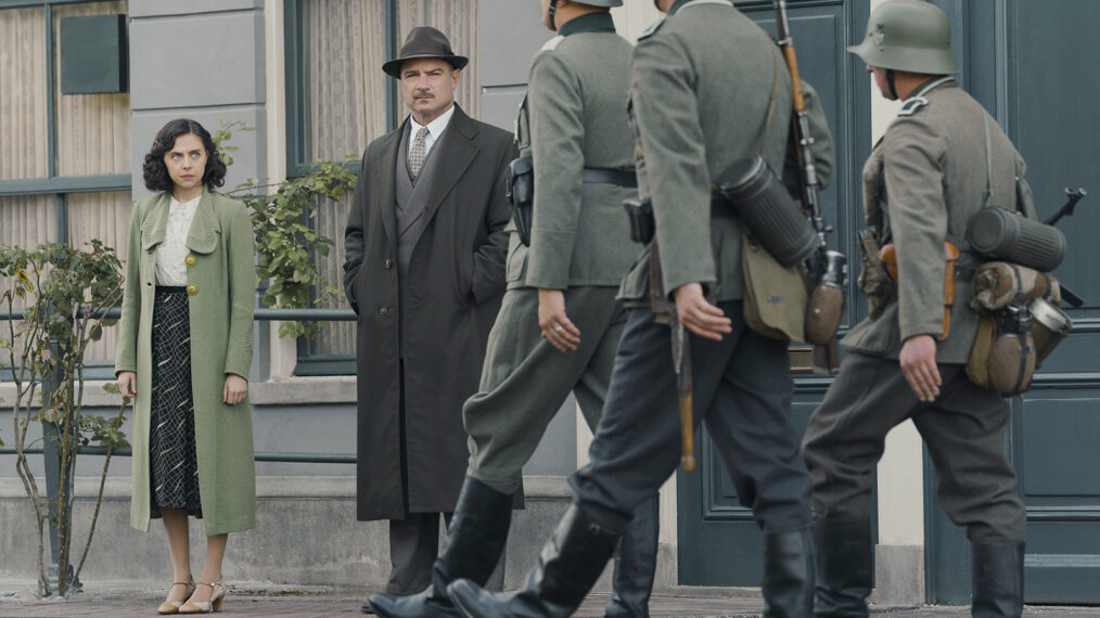 Miep Gies, played by Bel Powley, and Otto Frank, played by Liev Schreiber, watch as Nazi soldiers march down the street in Amsterdam.