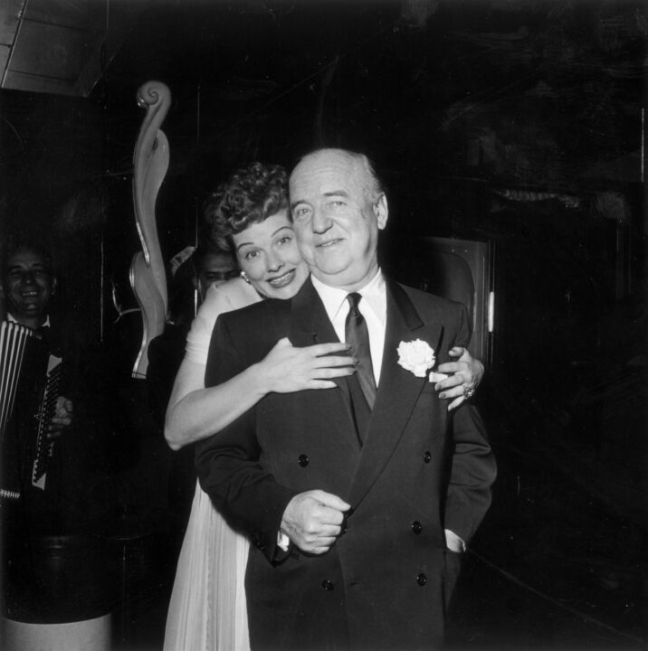 16th December 1953: American actor Lucille Ball (1911 - 1989) hugs American actor William Frawley (1887 - 1966) as she stands behind him during the surprise party for her 13th wedding anniversary to Cuban-born actor and singer Desi Arnaz, held at Larry Finley's restaurant on Sunset Strip, Los Angeles, California. Ball, Frawley, and Arnaz were costars in the television series 'I Love Lucy.'