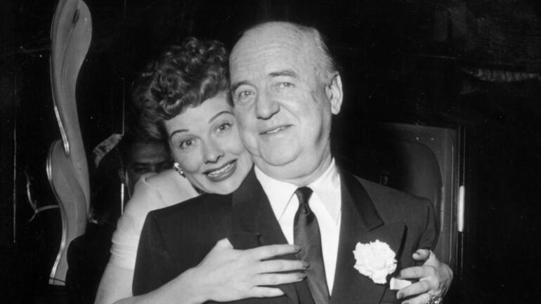 16th December 1953: American actor Lucille Ball (1911 - 1989) hugs American actor William Frawley (1887 - 1966) as she stands behind him during the surprise party for her 13th wedding anniversary to Cuban-born actor and singer Desi Arnaz, held at Larry Finley's restaurant on Sunset Strip, Los Angeles, California. Ball, Frawley, and Arnaz were costars in the television series 'I Love Lucy.'