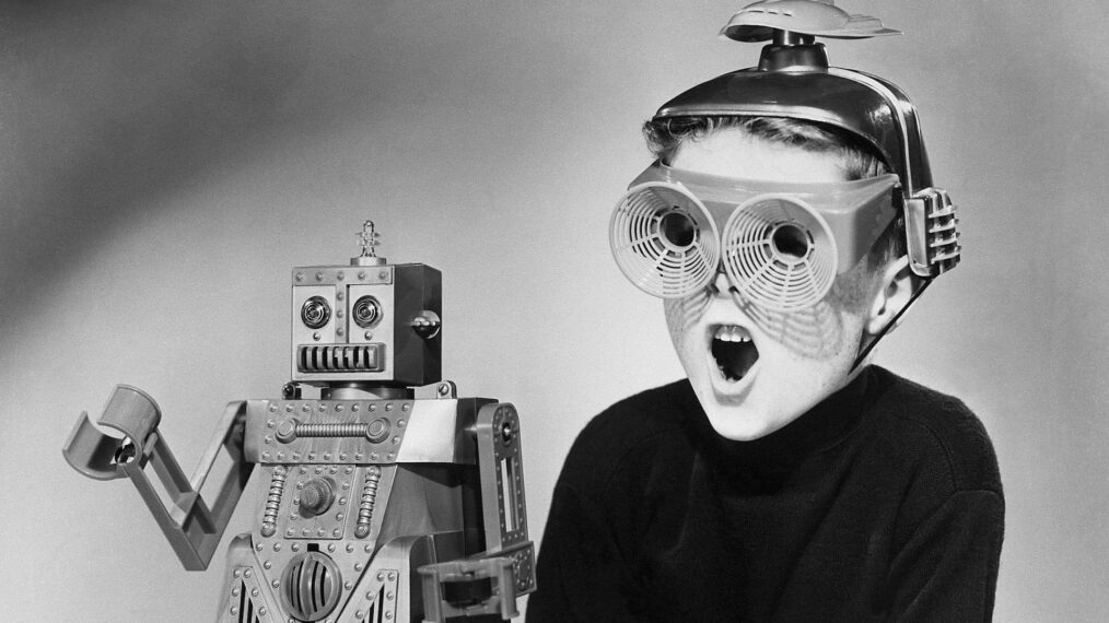 A boy wearing a futuristic space helmet and goggles demonstrates the wonders of Robert the Robot, a new toy manufactured by the Ideal Toy Corp. The robot will be showcased this summer at the American Fair in Moscow. It walks, it talks, its eyes light up - all by remote control, and for a 1959 price tag of about six dollars.