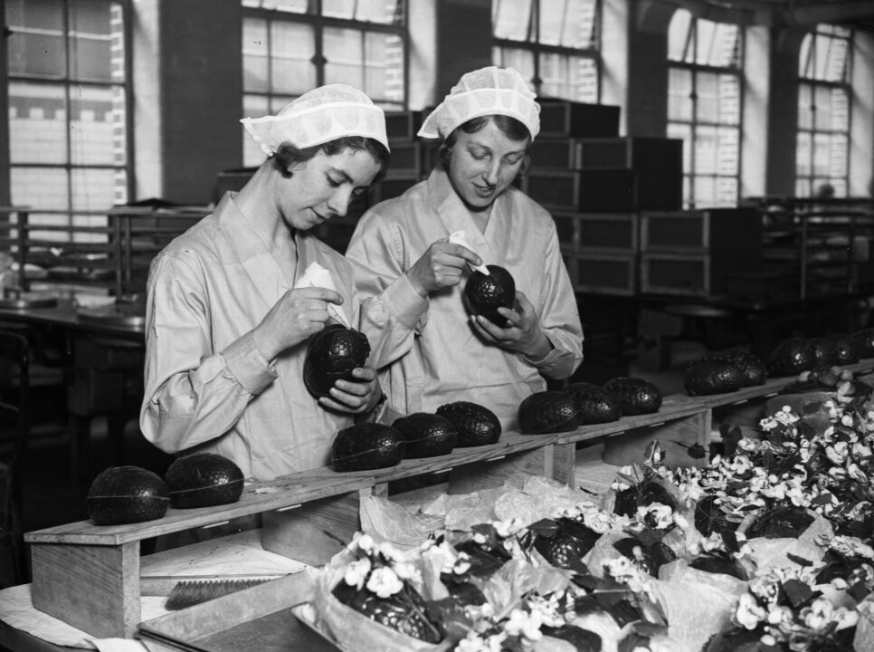 26th February 1932: Two women at the Cadbury's chocolate factory in Bournville, in the West Midlands join together chocolate Easter egg halves.