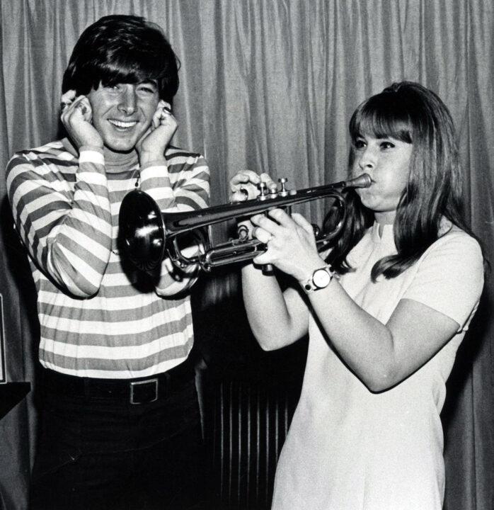 Ann Moses plays trumpet while Bobby Sherman humorously covers his ears