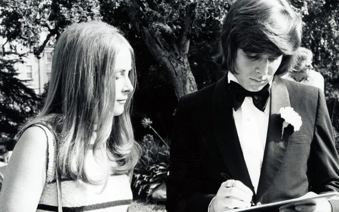 Bobby Sherman signs a paper as Ann Moses looks on