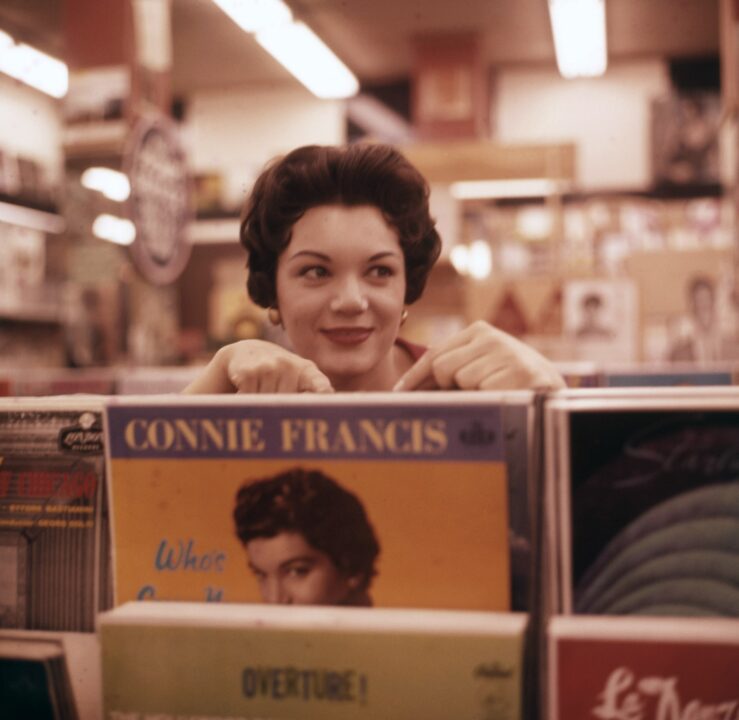 Connie Francis in a record store, holding her album 'Who's Sorry Now', circa 1958