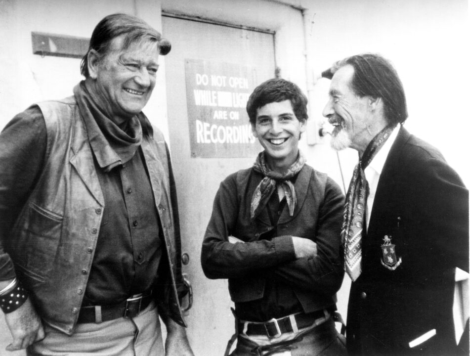 THE COWBOYS, John Carradine, right, visits John Wayne and Robert Carradine, on-set, 1972