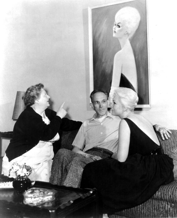 Kim Novak, right, and her parents, Joseph and Blanche Novak, admiring a caricature of her, 1959