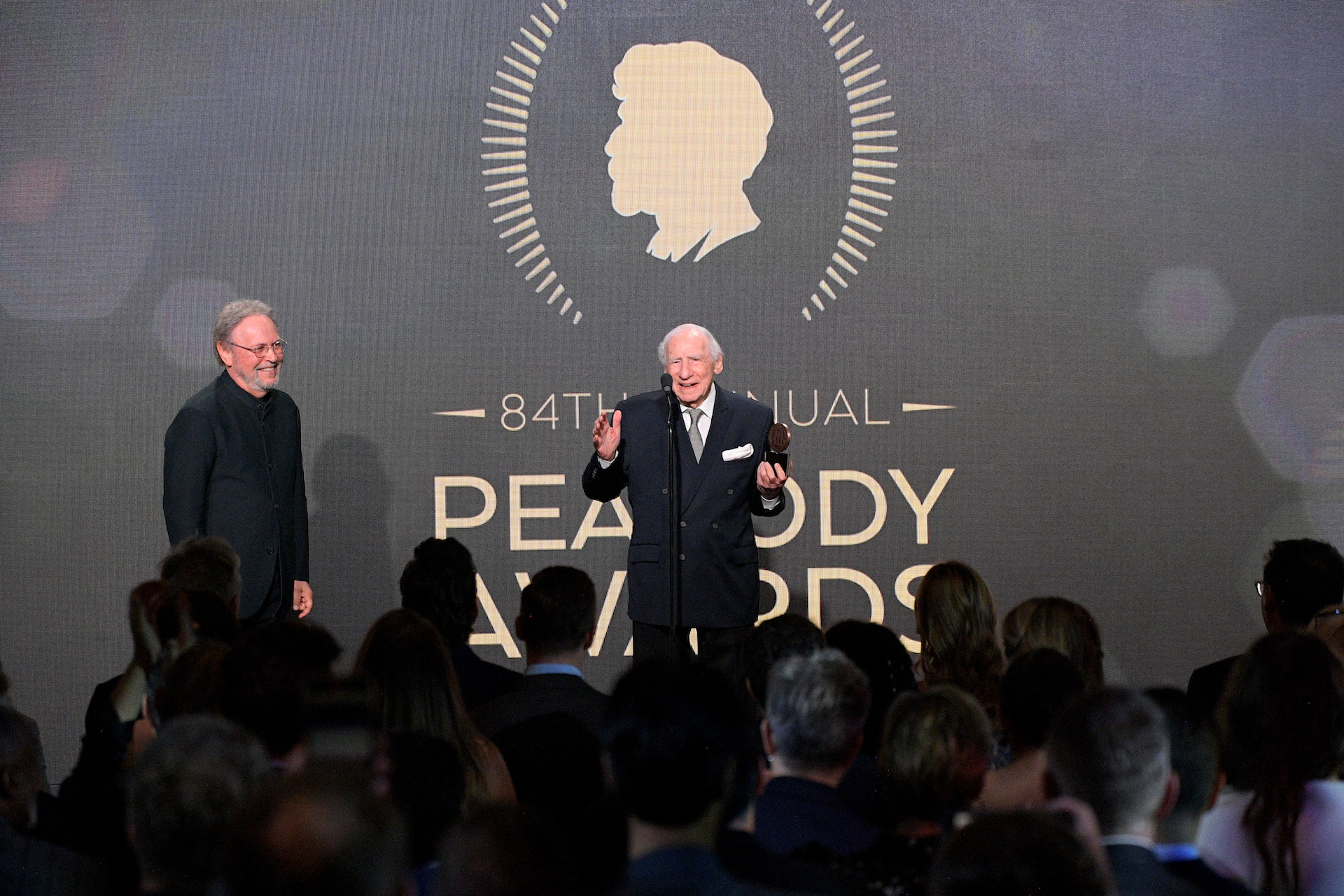 BEVERLY HILLS, CALIFORNIA - JUNE 09: Mel Brooks (R) accepts the Career Achievement Award from Billy Crystal onstage during the 2024 Peabody Awards at Beverly Wilshire, A Four Seasons Hotel on June 09, 2024 in Beverly Hills, California.