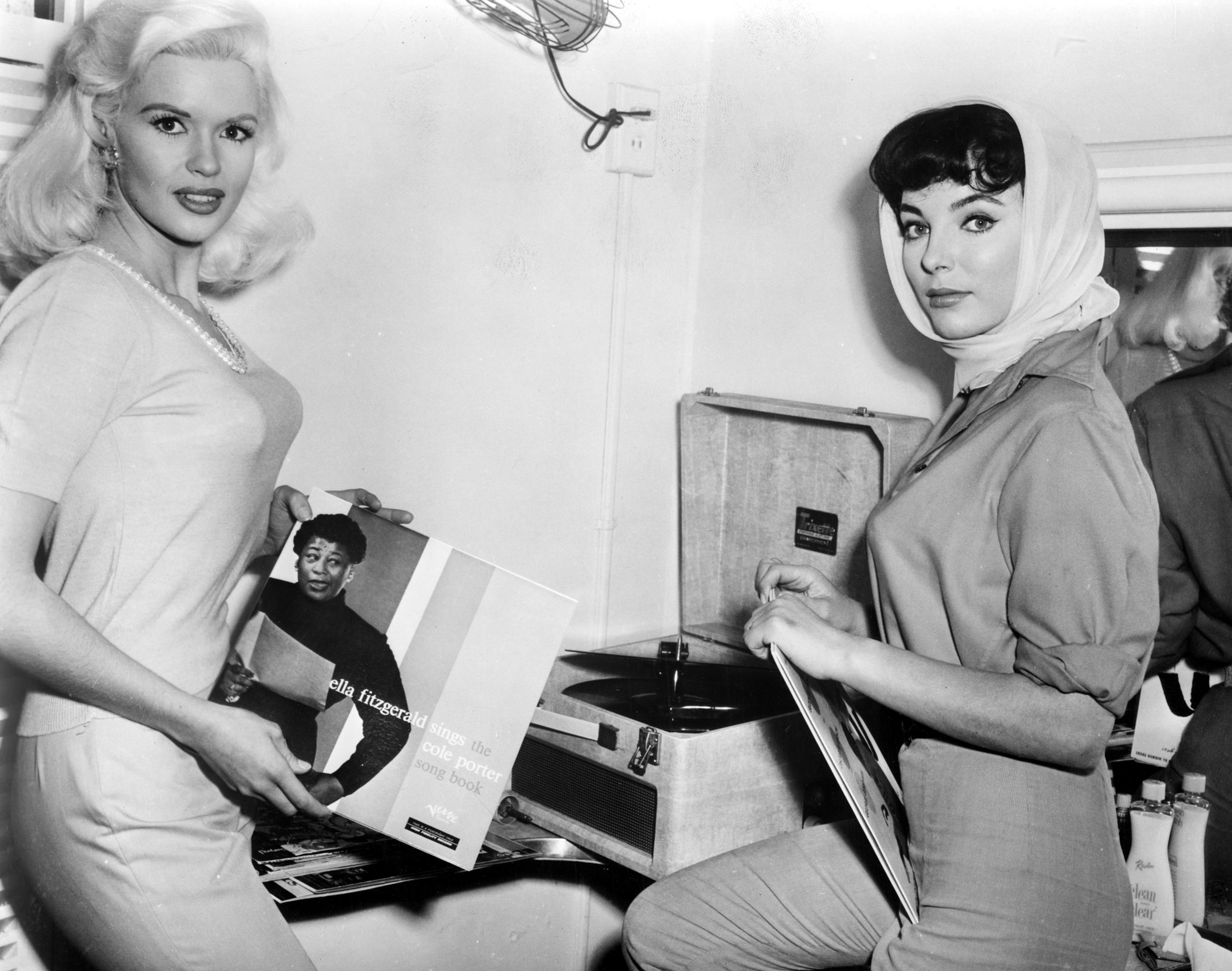Jayne Mansfield and Joan Collins listening to Ella Fitgerald records in a dressing room on the 20th Century Fox lot, publizising THE WAYWARD BUS, 1957