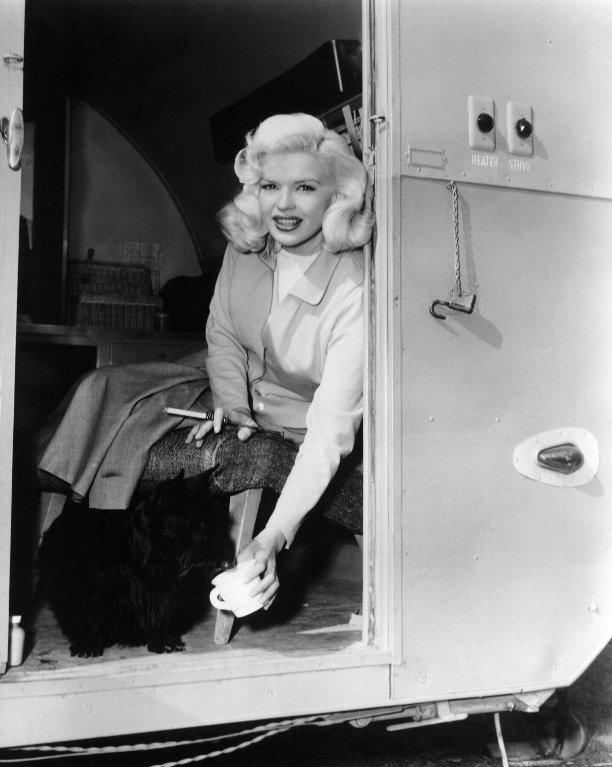 THE WAYWARD BUS, Jayne Mansfield shares refreshment with her dog in her trailer on set, 1957