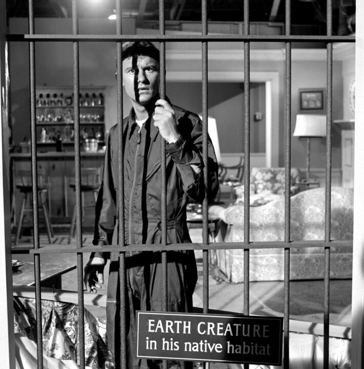 Actor Roddy McDowall stars in the 'People Are Alike All Over' episode of the CBS television series "The Twilight Zone" on March 25, 1960. He is seen wearing his astronaut uniform, standing in a cage and clutching the bars in confusion and fright. A sign in front of the cage reads: "Earth creature in his native habitat."