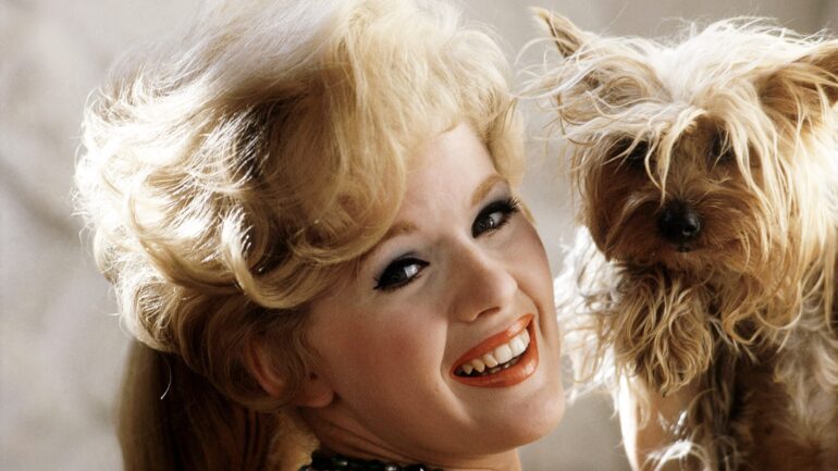Connie Stevens pictured with a dog, 1962.