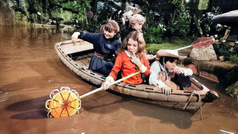 The chocolate room of candy-maker supreme, Willy Wonka, may go down in screen history as not only one of the most impressive studio sets ever constructed but perhaps the tastiest too. The immense candy room setting has been constructed on the largest sound stage at Bavaria Studios, Munich, where David L. Wolper's production of 'Willy Wonka and the Chocolate Factory' is now being filmed. Sailing in the boat are Denise Nickerson, Peter Ostrum, Julie Dawn Cole and Paris Themmen (this is not the boat used in the film). They are using giant lollipops as paddles. 8th October 1970. Colorized