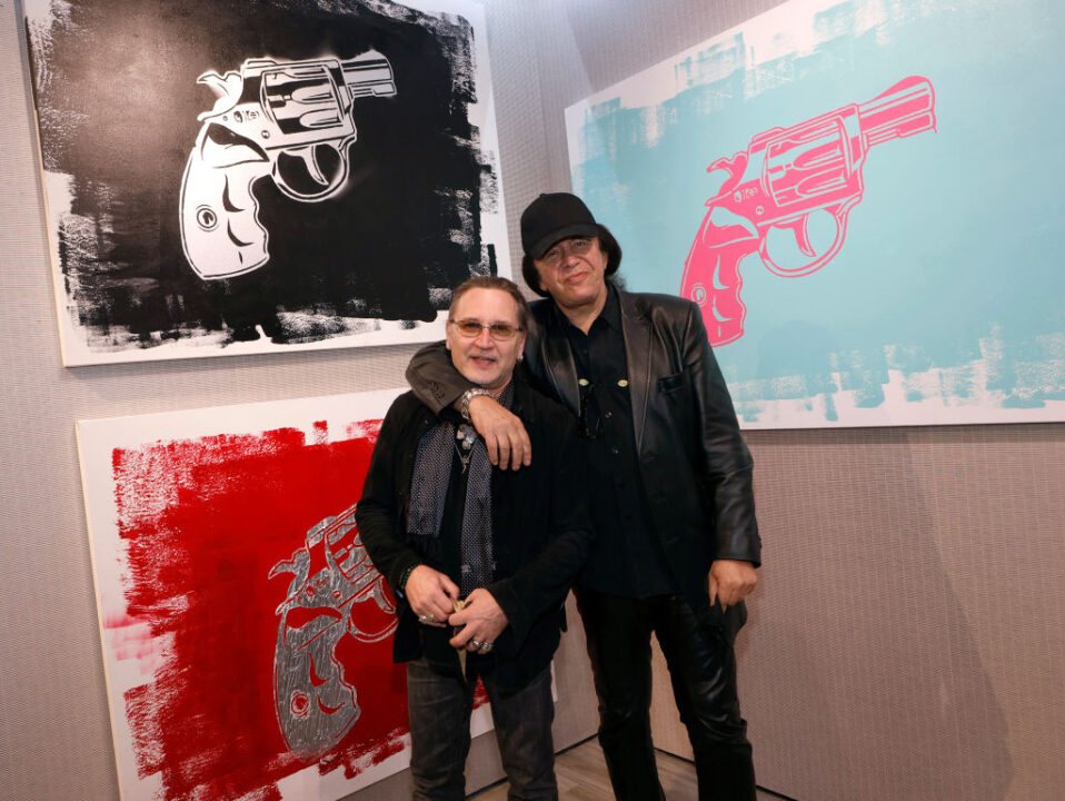 Kiss drummer Eric Singer (L) and Kiss singer/bassist Gene Simmons pose in front of some of Simmons' works at the debut of Gene Simmons ArtWorks at Animazing Gallery at The Venetian Las Vegas on October 21, 2021 in Las Vegas, Nevada