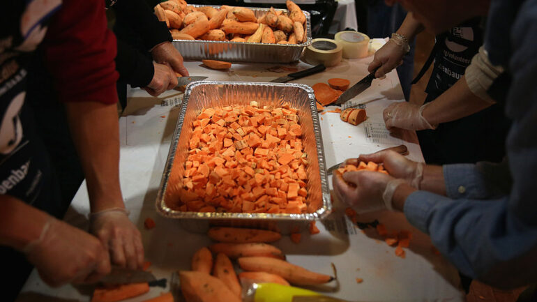 Volunteers chop yams as they participate in the annual Everything But The Turkey, an event partners with DC Central Kitchen, to prepare Thanksgiving dishes for those in need November 25, 2013 at the DCJCC in Washington, DC. Hundreds of volunteers from the DC area gathered to help prepare more than 20,000 servings of holiday dishes, including yams, stuffing, coleslaw, green beans, and a bean salad, which will be distributed to 100 area social service agencies for Thanksgiving