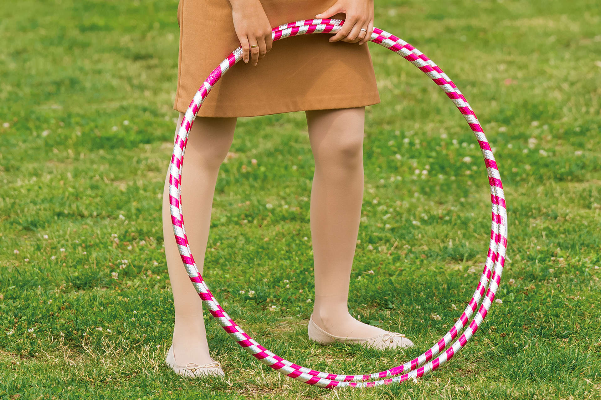 Hula hoop massage hoop for weight loss on the background of grass in the open air, close-up, outdoor.