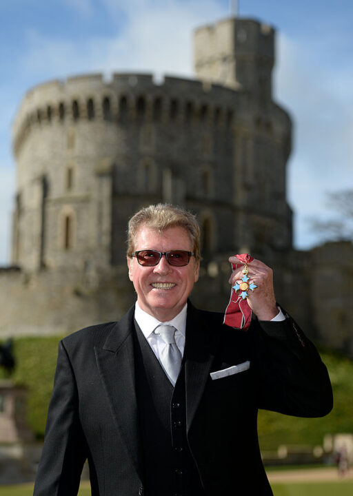 Michael Crawford poses after being made Commander of the Order of the British Empire (CBE) for charitable and philanthropic services during an Investiture ceremony at Windsor Castle on March 7, 2014 in Windsor, England