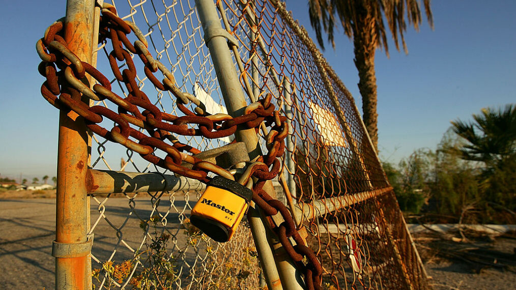 A lock and chain hangs on a fence at a defunct yacht club on October 20, 2005 in Salton City, California. A controversial plan put forth by the Salton Sea Authority board, the agency that manages the Salton Sea, proposes building up to 200-thousand homes, including some on a former atomic weapons testing site, to help fund restoration of the lake which reportedly faces ecological collapse. Critics fear the shuttered Salton Sea Test Base is polluted with depleted uranium that could threaten the health of future residents, and that such a development boom could eliminate resting and nesting places for the more than 400 species of birds using this important migratory stop-over that the restoration plan is supposed to help