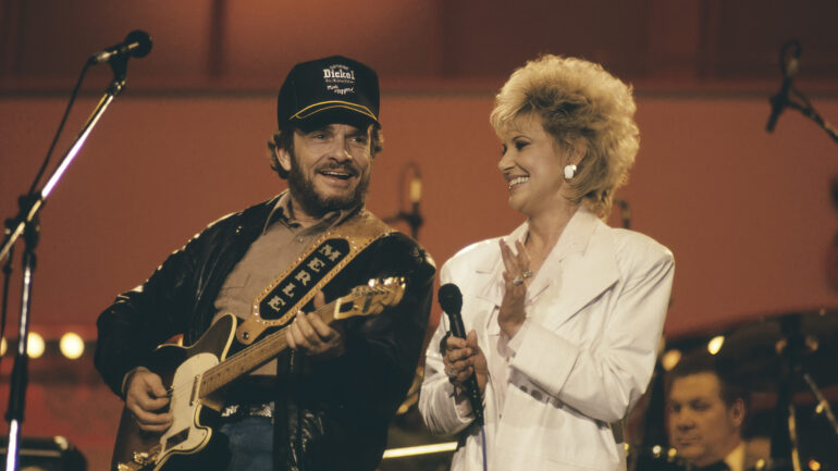 American singer-songwriters Merle Haggard and Tammy Wynette performing a duet on stage at the International Festival Of Country Music at Wembley Arena, London, April 1988.