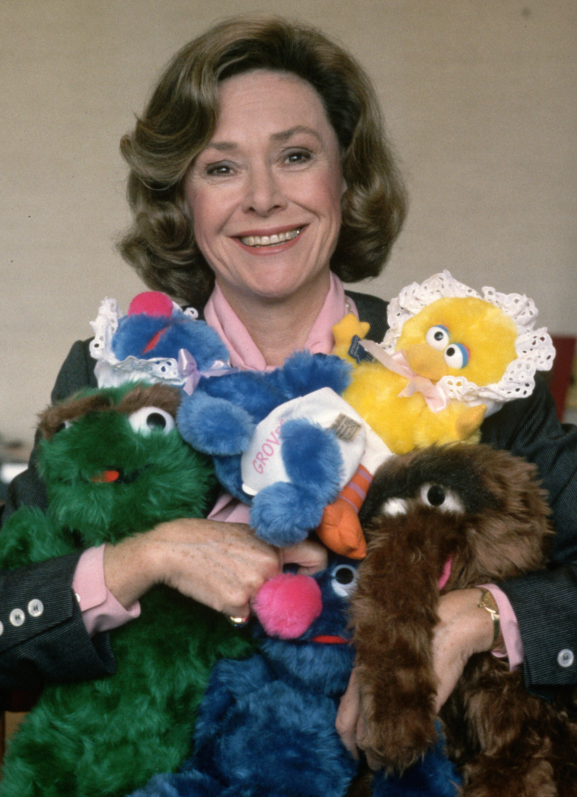 Joan Ganz Cooney, founder of The Children's Television Workshop, holding 'Sesame Street' characters, October 1st 1985. 